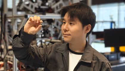 A researcher holds up the swallowable SeroTab capsule in the robotics lab at the University of Twente