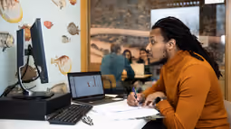 student looking at computer screen while studying