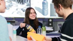 Team discussion on bottle designs with industrial visuals, highlighting strategic decision-making in product development processes.
