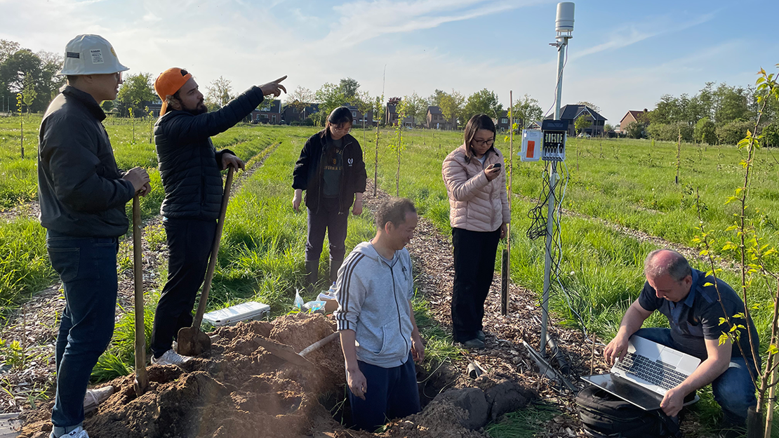 A group of scientists sampling and monitoring soil.