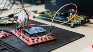 Workspace featuring electronic circuit boards interconnected with colorful wires in a close-up view.