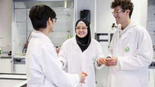 Chemical Science and Engineering students working in lab wearing white coats