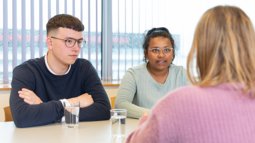 Students at table talking about Conflict, Risk & Safety