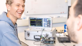 Embedded Systems students work with an oscilloscope and electronic equipment on a lab bench.