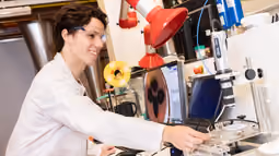 Lab work with microscopic imaging and instruments, illustrating material analysis and flow behavior in energy systems.