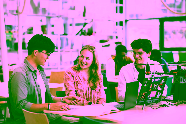 Three students at the University talking with a drone on the table