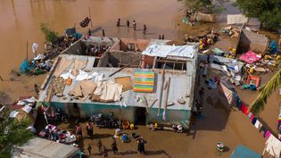 Flooded residential area with visible damage and community response, highlighting disaster resilience and humanitarian recovery efforts.