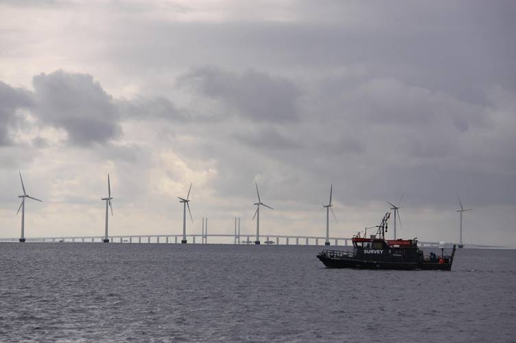A boat in the water with wind turbines in the background

AI-generated content may be incorrect.