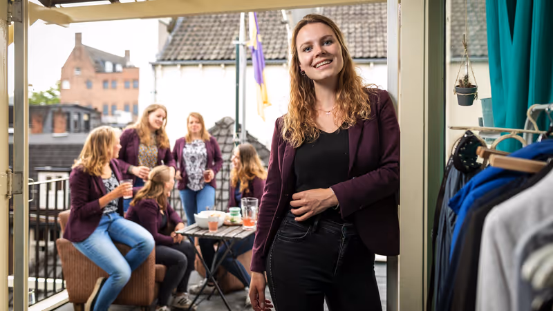 A group of members of a student association are hosting a drink on a roofterrace.