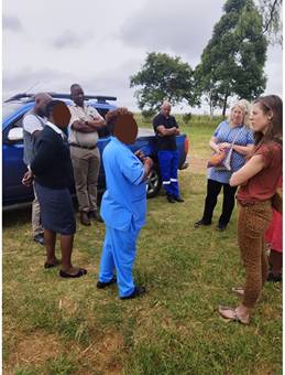 A group of people standing in a grass field

AI-generated content may be incorrect.