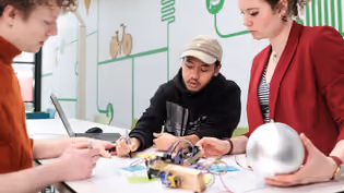 Collaborative work on tech prototype, illustrating the interplay between human interaction, design, and emerging technologies.