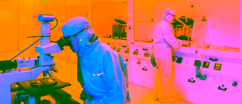 Researchers in cleanroom suits working on nanotechnology experiments