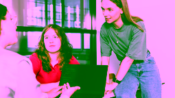Three students analysing code on a laptop during a project meeting.
