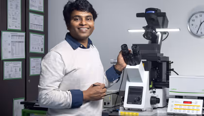 Researcher Rao Vutukuri at a microscope conducting research into synthetic bacteria
