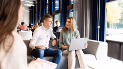 students on couch looking at laptop
