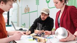 Collaborative work on tech prototype, illustrating the interplay between human interaction, design, and emerging technologies.