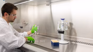 Biomedical engineering student conducts an experiment in the lab using pipettes and laboratory equipment.