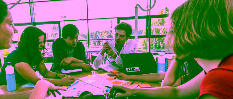 Students looking at a phone and laptop at UT