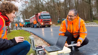 On-site roadwork inspection using digital tools, highlighting project monitoring and data-driven decision-making in construction.