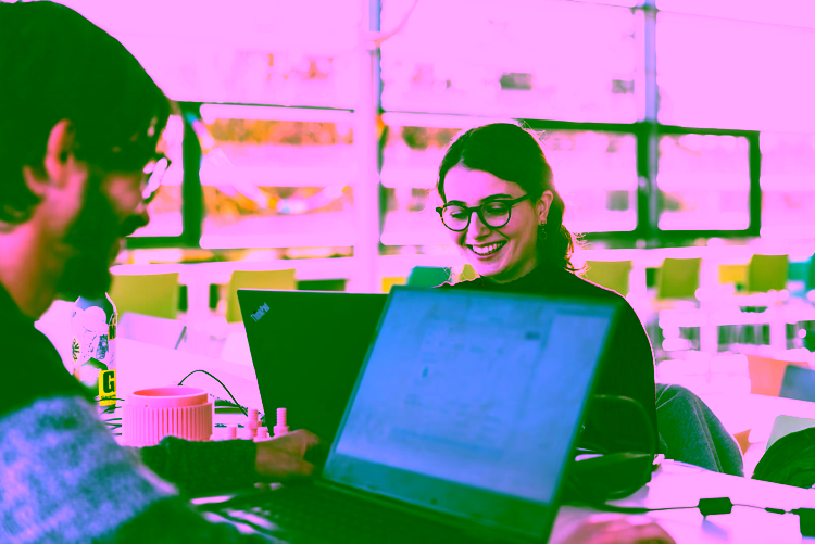 A student of the University of Twente smiling and working.