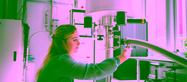 Student is adjusting a setup and taking measurements in a laboratory for quantum research.