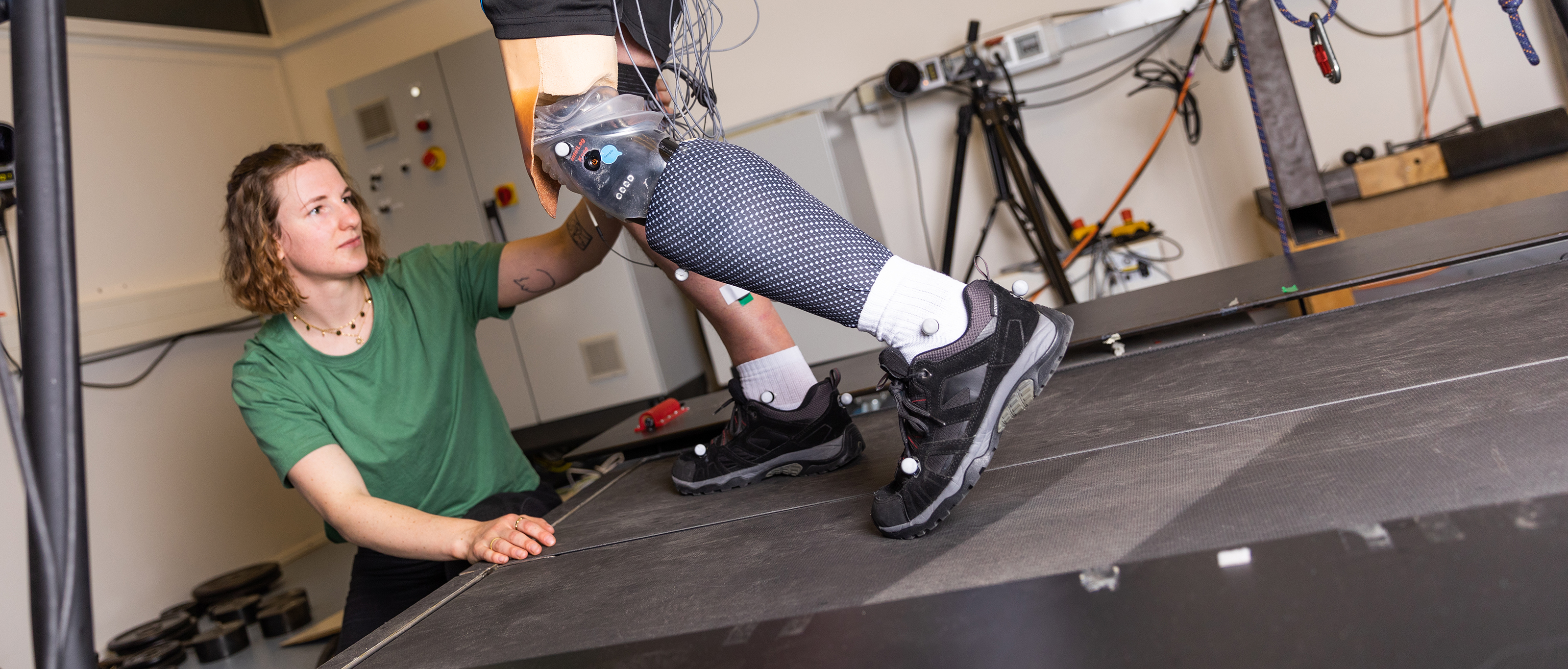 Biomedical Engineering student conducts measurements on a patient with a new prosthesis on a treadmill.
