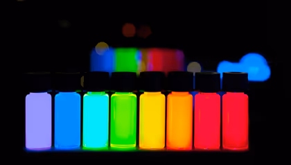 Vials of glowing quantum dot solutions displaying the full colour spectrum