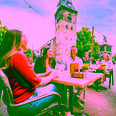 Terrace in Enschede with people and Grote Kerk in the background.