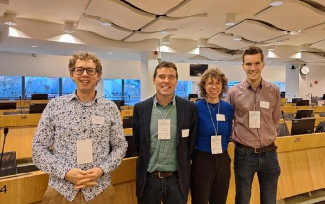 A group of people standing together with tags on their shirts

AI-generated content may be incorrect.