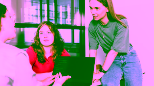 Three students analysing code on a laptop during a project meeting.
